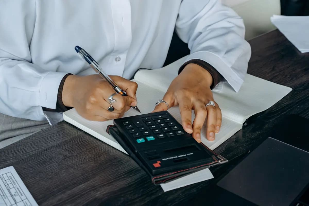 Une professionnelle de santé fait un calcul à la calculatrice et note le résultat