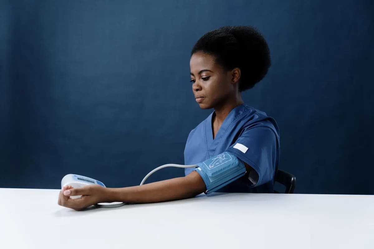 Une infirmière mesure la tension artérielle avec un tensiomètre électronique