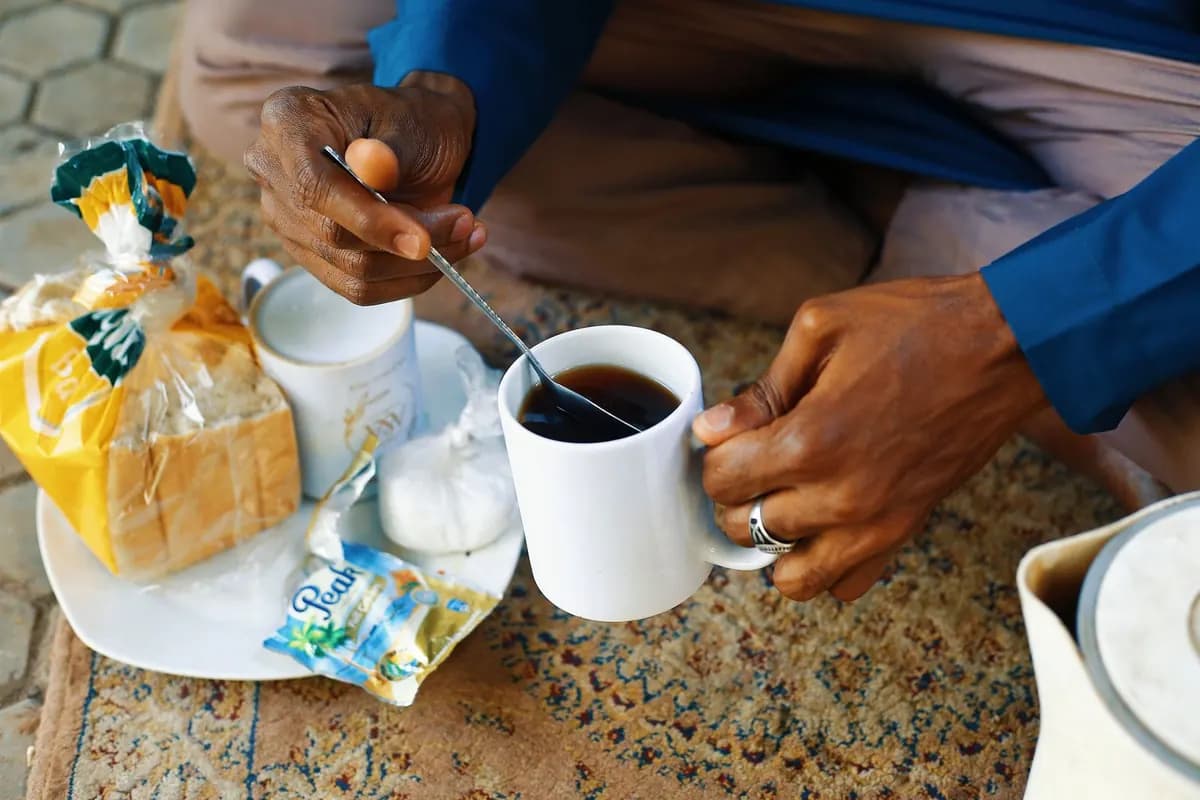 Un petit-déjeuner avec du pain et une tasse de thé, servi à la maison