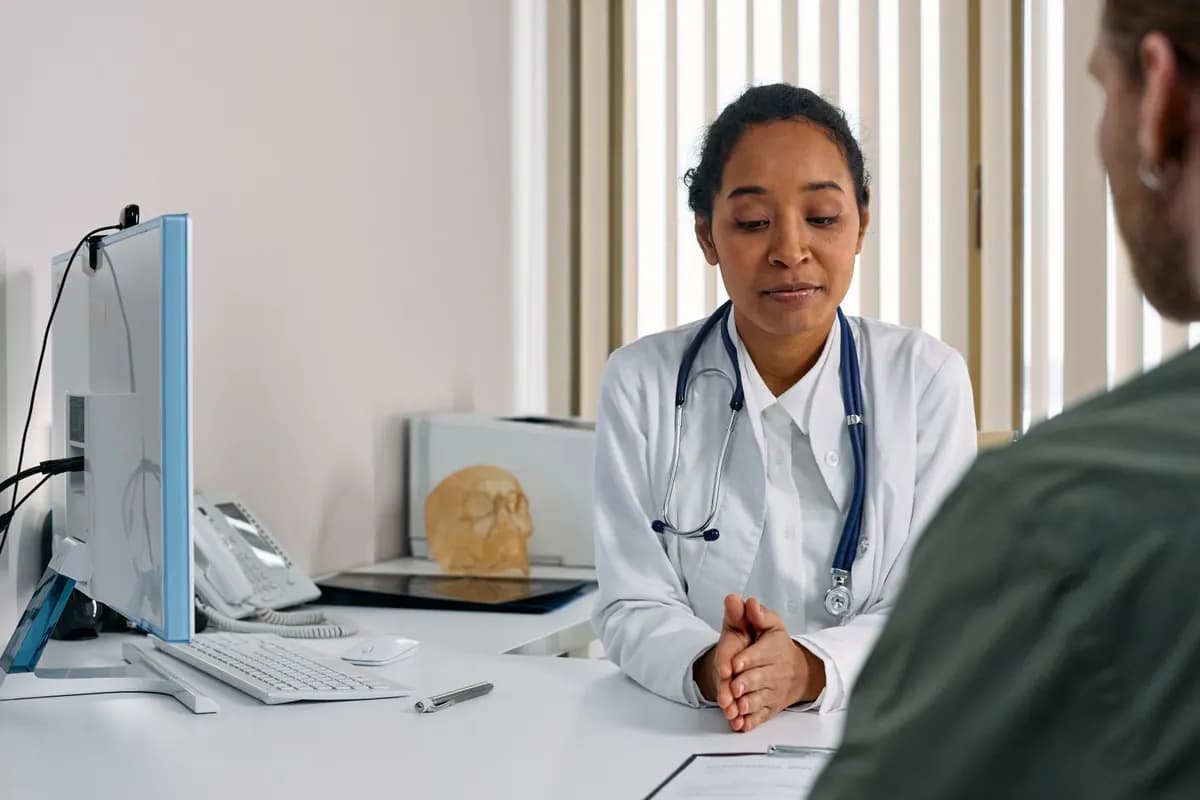 Une médecin échange avec un patient à son bureau de consultation
